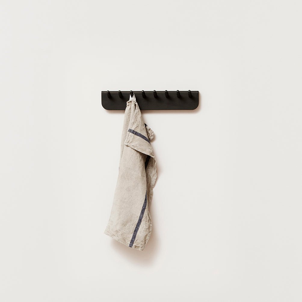 An Echo Coat Rack 40 by Form & Refine with a towel hanging on it in Gestalt Haus style.