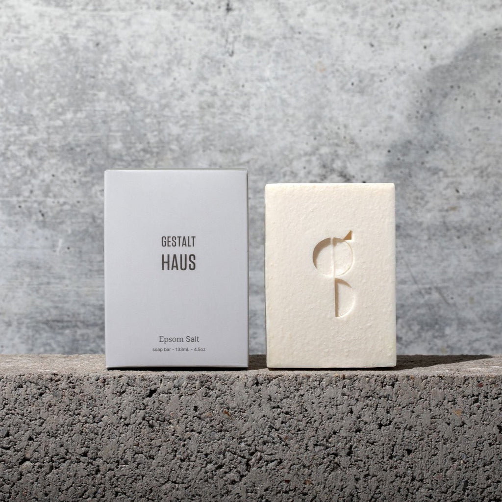 A box of Gestalt Haus EPSOM SALT BAR SOAP with the logo on it next to a concrete wall.