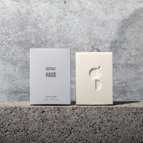 A box of Gestalt Haus EPSOM SALT BAR SOAP with the logo on it next to a concrete wall.