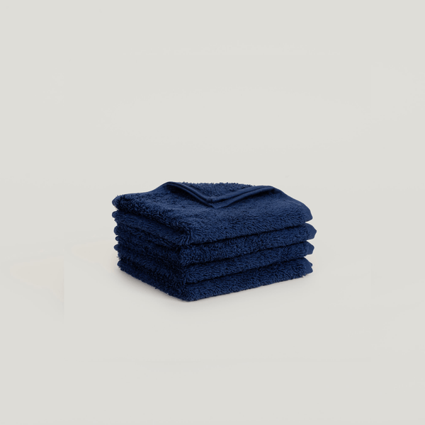 A stack of blue face washers from Gestalt Haus on a white background.