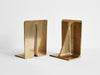 Two STUDIO HENRY WILSON FIN BRASS BOOKENDS on a white surface showcasing the Gestalt Haus.