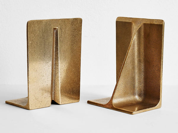 Two FIN brass bookends by STUDIO HENRY WILSON on a white surface at Gestalt Haus.