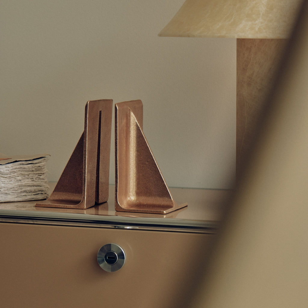 Studio Henry Wilson's Fin Brass Bookends on a dresser next to a lamp in the Gestalt Haus.