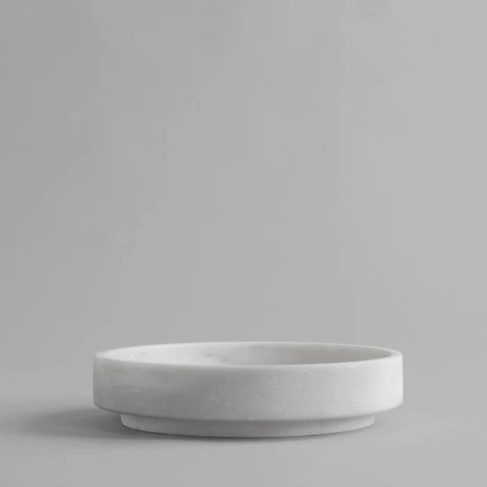 A small white FORMALISM BOWL showcasing the minimalist aesthetic of 101 COPENHAGEN, resting on a sleek gray surface.