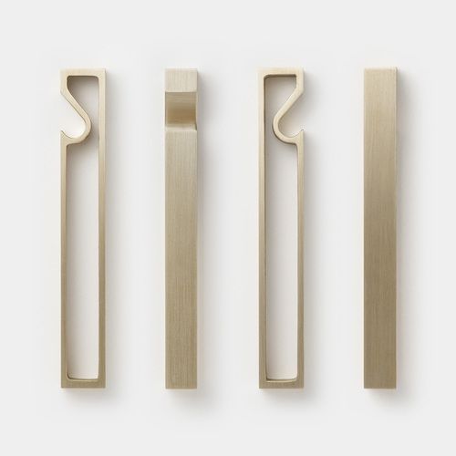 A set of FUTAGAMI FRAME BOTTLE OPENER door handles on a white surface, inspired by Gestalt Haus design principle.