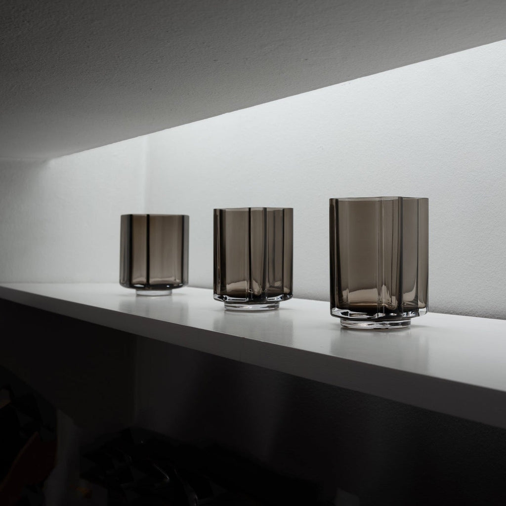 Three FUNKI VASE ASYMMETRIC glass vases by LOUISE ROE sit on a shelf in a room at Gestalt Haus.