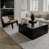 A living room with white walls and black furniture from LOUISE ROE GALLERY OBJECT BOWL.