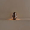 A Gemma table lamp placed on a Gestalt Haus table in front of a wall.