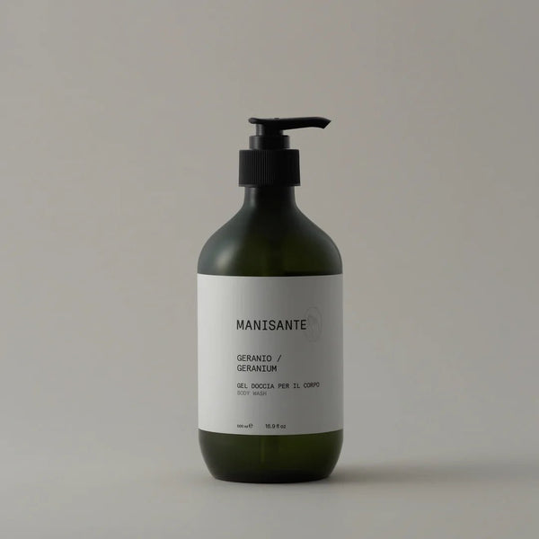 A bottle of MANISANTE GERANIUM BODY WASH on a white background, with Gestalt Haus elements.