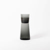 A black Glass Carafe designed by Gary Bodker Designs sitting on a white surface at the Gestalt Haus.