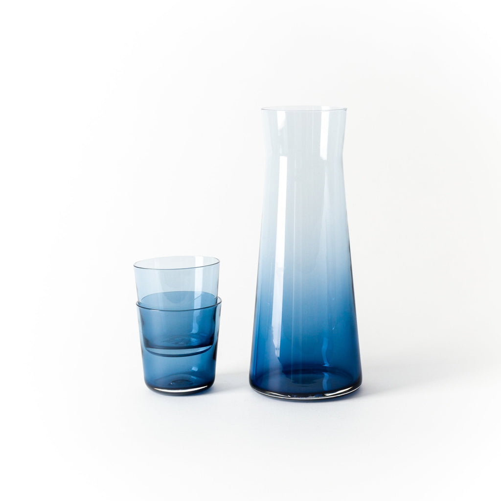 A GLASS Gestalt Haus CARAFE by GARY BODKER DESIGNS next to each other.