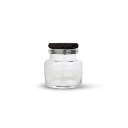 A clear glass container with a black lid by LOUISE ROE.