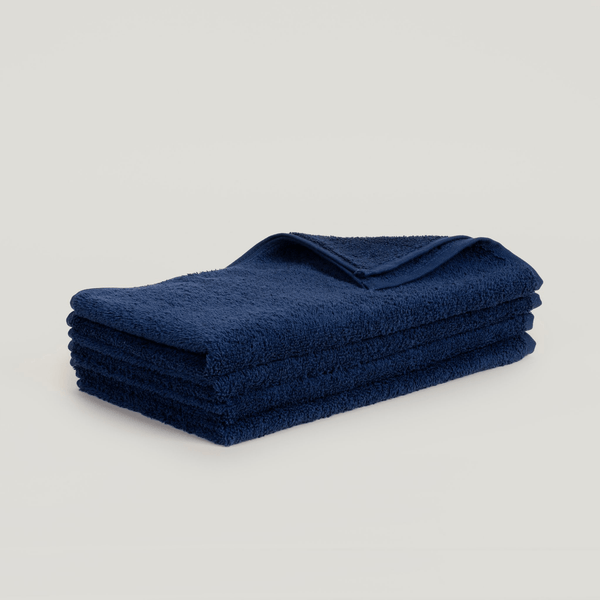 A set of hand towels folded on top of each other, with Gestalt Haus branding.