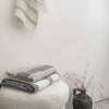 A black and white striped Hand Woven Towel Collection from Sera Helsinki displayed on a wall.