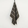 A SERA HELSINKI black and white striped HAND WOVEN towel collection hanging on a Gestalt Haus hook.