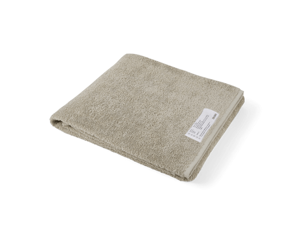 A beige HEAVY TOWELS BY FRAMA on a white background at Gestalt Haus.