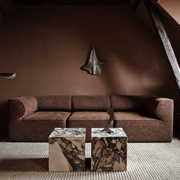 A living room with a brown couch and Gestalt Haus.