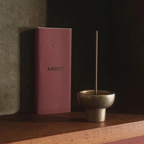 Studio Henry Wilson Gestalt Haus incense burners on a shelf next to a book.