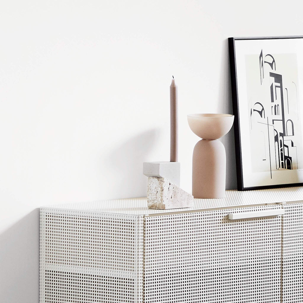 A white sideboard with an OFFSET CANDLEHOLDER VOL. 1 by KRISTINA DAM STUDIO and a framed picture.