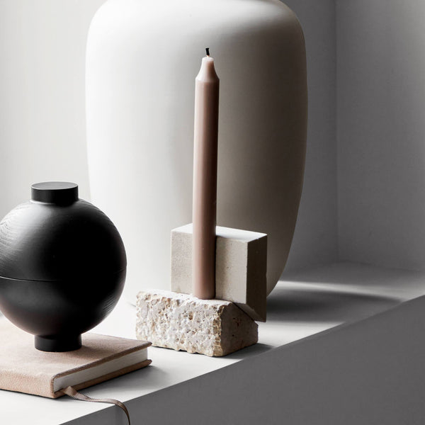 A vase with an OFFSET CANDLE HOLDER VOL. 2 and a book on a window sill by KRISTINA DAM STUDIO in the Gestalt Haus style.
