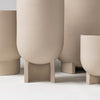 A group of beige FLOWERPOT vases from KRISTINA DAM STUDIO on a white surface.