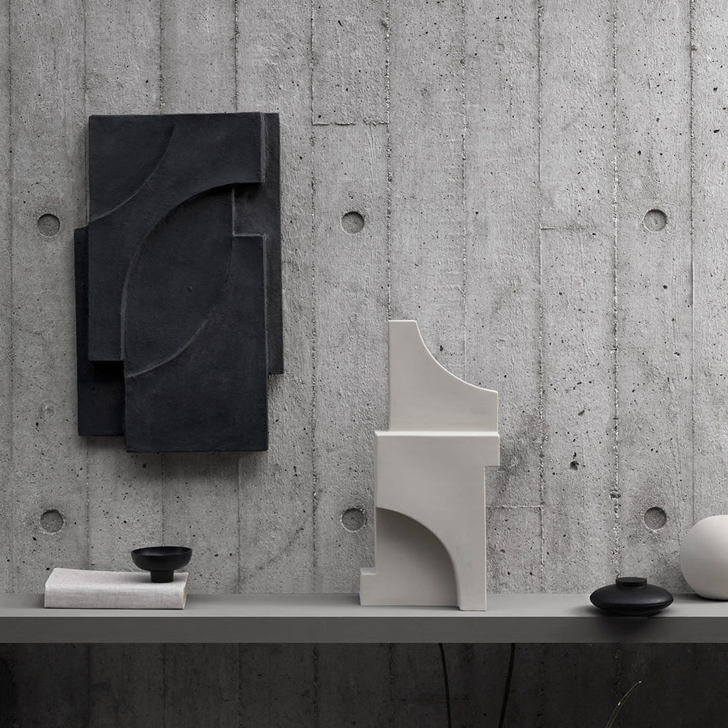A KRISTINA DAM STUDIO sculpture shelf featuring a black vase and a white vase.
