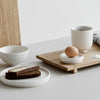 A tray with bread, eggs and a coffee cup from the KRISTINA DAM STUDIO SETOMONO collection sits at Gestalt Haus.