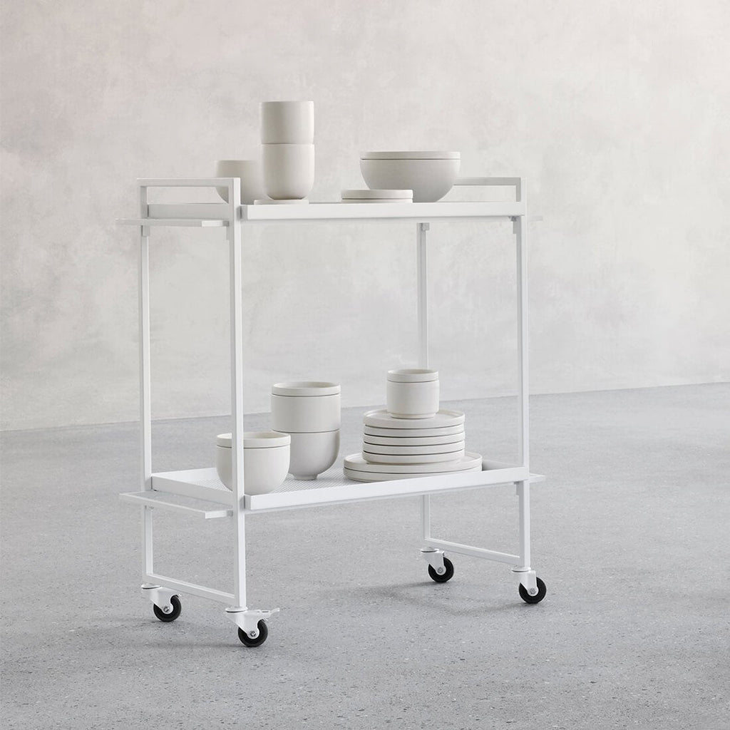 A white SETOMONO CONTAINER serving cart with plates and bowls on wheels by Kristina Dam Studio, embodying the essence of Gestalt Haus.