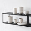 A white shelf showcasing several SETOMONO DINNER + SIDE PLATES by KRISTINA DAM STUDIO in a Gestalt Haus.