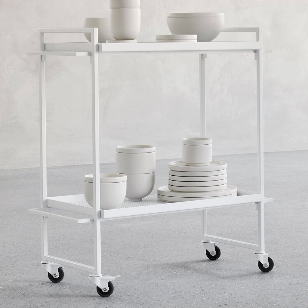 A white cart with SETOMONO DINNER + SIDE PLATES and bowls on it from KRISTINA DAM STUDIO, available at Gestalt Haus.