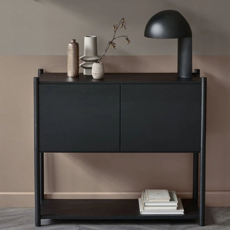 A black console table with a GEJST LEERY TABLE LAMP atop, showcasing Gestalt Haus aesthetics.