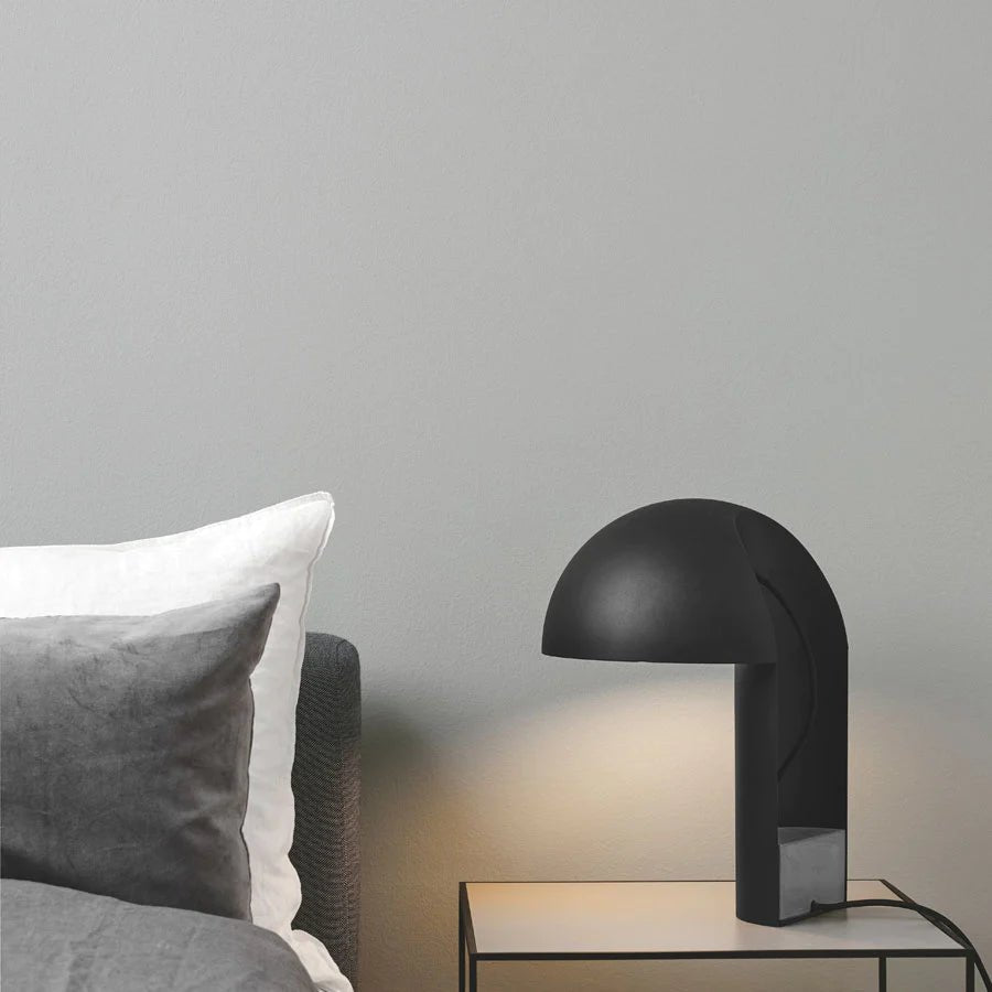 A bed with a GEJST bedside table and a LEERY TABLE LAMP in the Gestalt Haus style.