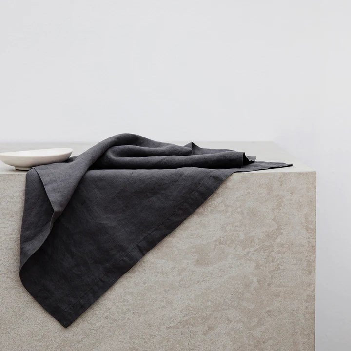 A black linen napkin from CULTIVER sits on top of a Gestalt Haus table.