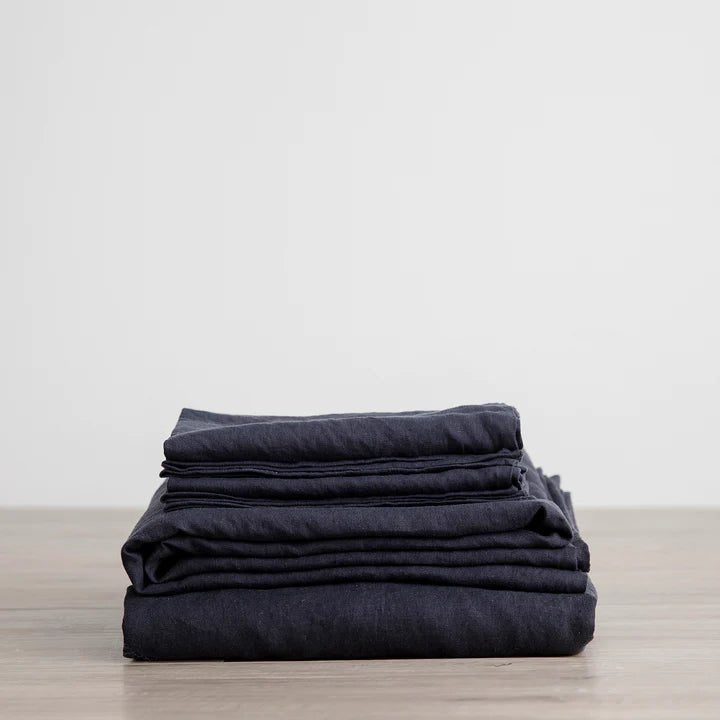 A stack of CULTIVER LINEN SHEET SET on a wooden table.