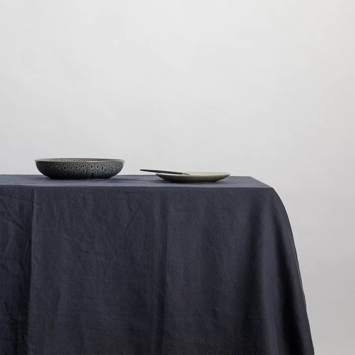 A CULTIVER linen tablecloth adorned with a bowl and plate from Gestalt Haus.
