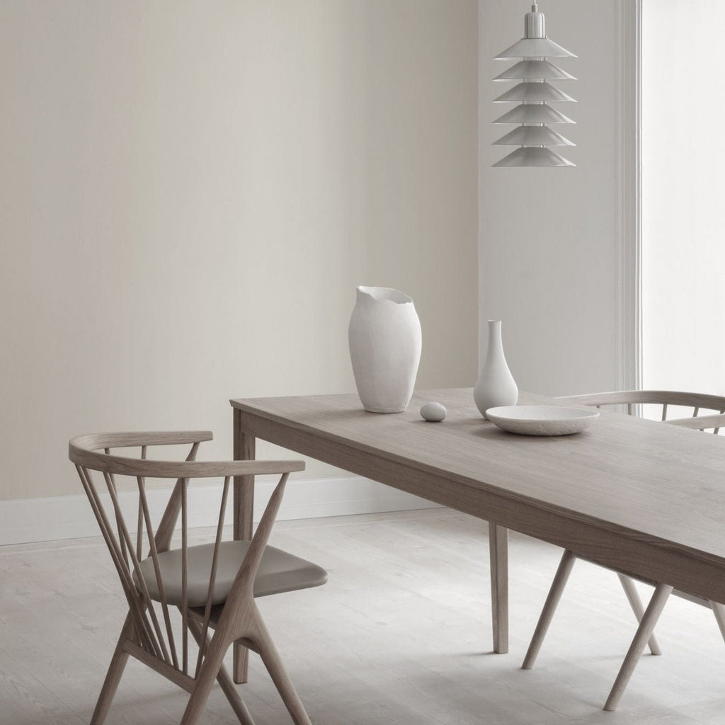A SIBAST wooden table and chairs in a white Gestalt Haus dining room.