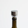 A bottle of MASS WINE STOPPERS with a Gestalt Haus stopper on it.