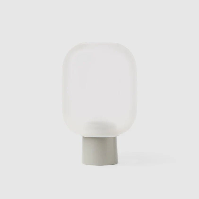 A small NEBL FLOWERPOT vase sitting on a white surface, produced by the brand GEJST known for their minimalist designs inspired by Gestalt principles.