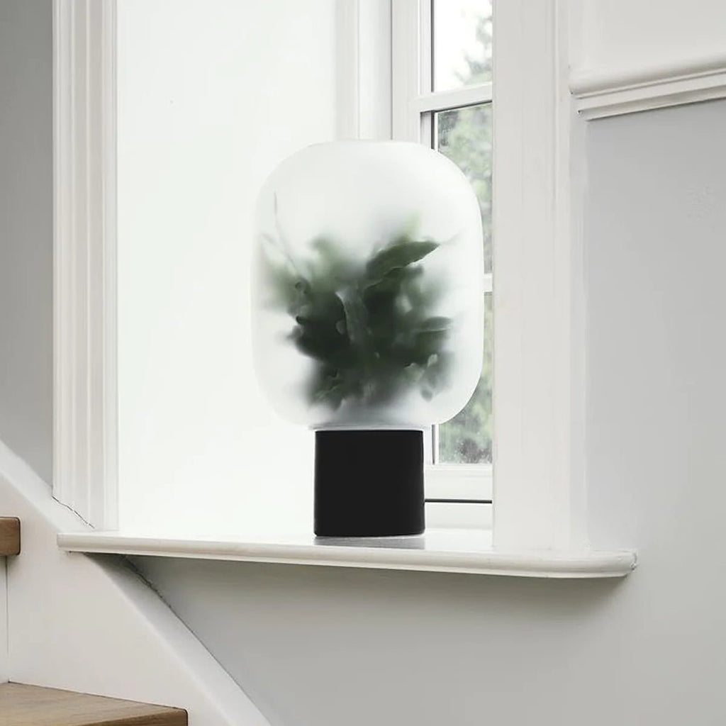 A NEBL FLOWERPOT by GEJST with a plant on it sits on a window sill at Gestalt Haus.