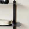 A black NIVO SHELF E by GEJST displaying plates and bowls at Gestalt Haus.