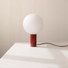 A Gestalt Haus ORB TABLE LAMP with an IN COMMON WITH ball on it.