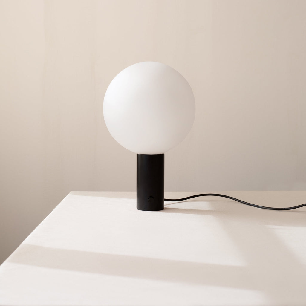 An IN COMMON WITH ORB TABLE LAMP on a white table at Gestalt Haus.