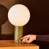 An ORB TABLE LAMP with a green sphere on it, IN COMMON WITH Gestalt Haus.