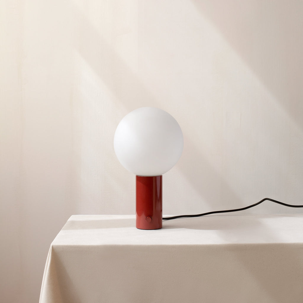 An IN COMMON WITH ORB TABLE LAMP with a red sphere on it from Gestalt Haus.