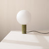 A green ball IN COMMON WITH ORB TABLE LAMP in the style of Gestalt Haus.