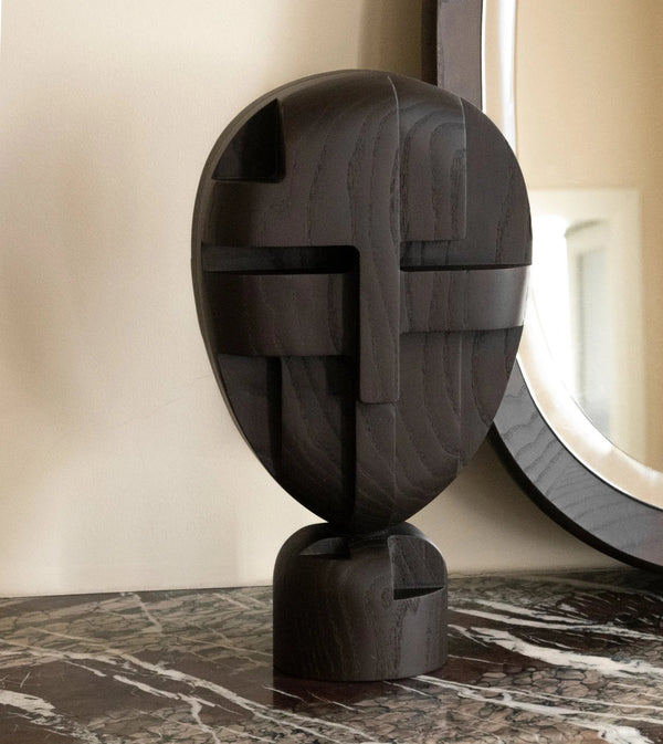 An ORIGIN MADE black sculpture sits on a table next to a mirror in the Gestalt Haus.