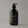 A bottle of OUD SHAMPOO by MANISANTE on a grey background with Gestalt Haus influence.