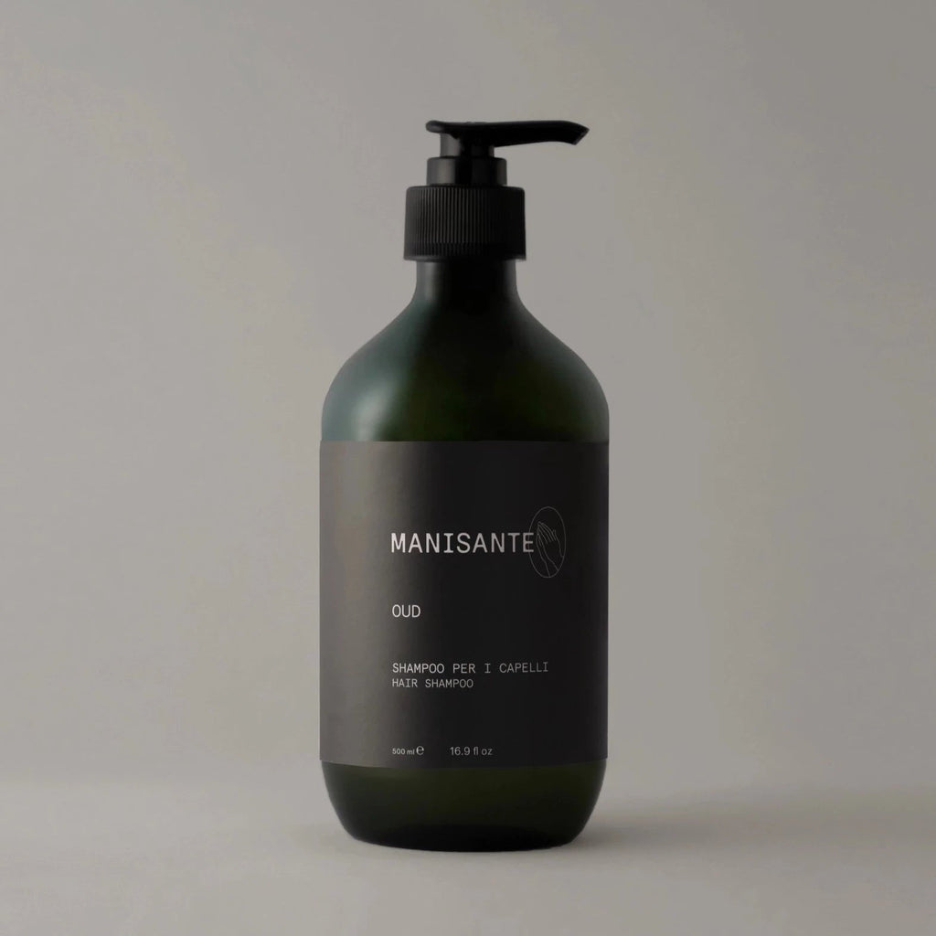 A bottle of OUD SHAMPOO by MANISANTE on a grey background with Gestalt Haus influence.