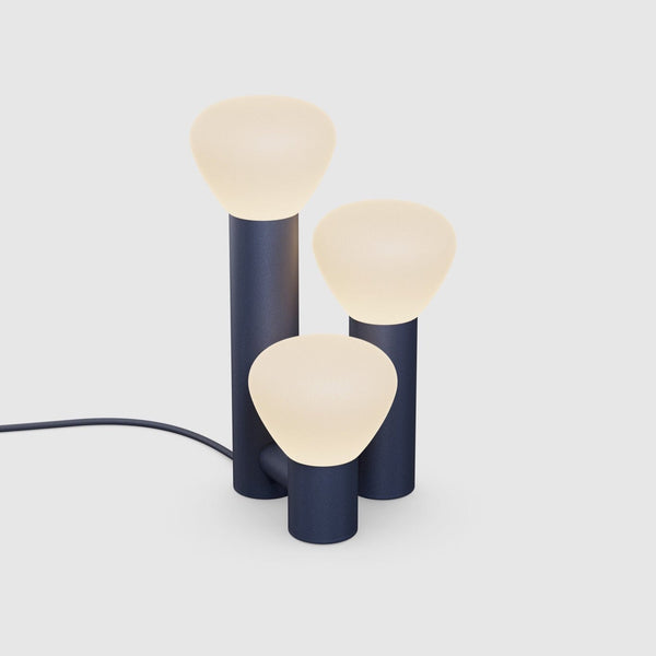 A PARC 06 TABLE LAMP with three lights on it, by LAMBERT ET FILS, creating a Gestalt Haus atmosphere.