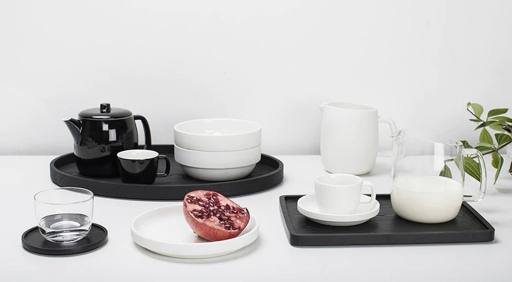 A white Gestalt Haus tray with black and white Serax mugs, cups, and saucers.